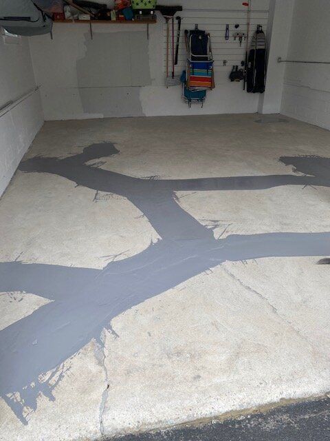 An empty garage with a cracked concrete floor