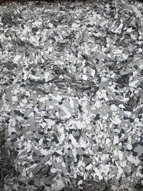 A pile of gray , white , and black rubber chips.