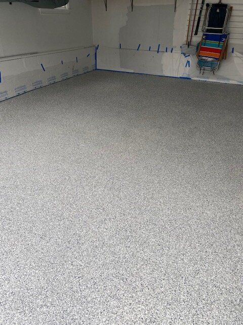 A garage with a gray floor and white walls.