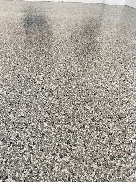 A close up of a gray carpeted floor in a room.