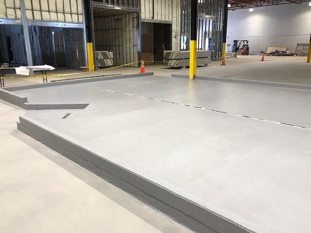 A large brewery with a concrete floor and a table in the middle.