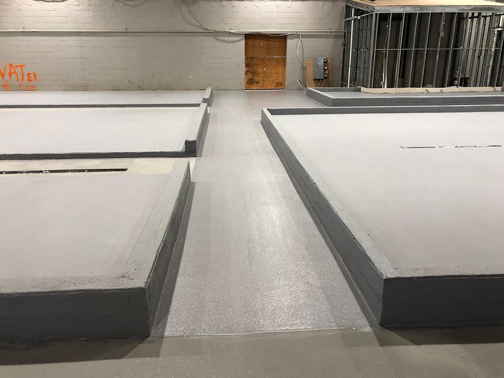 A large room with a concrete floor and a wooden door.