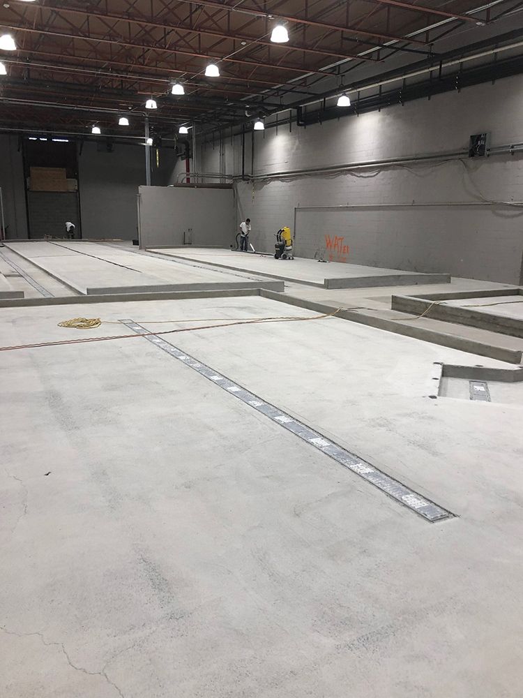 A large empty brewery with a lot of concrete floors.