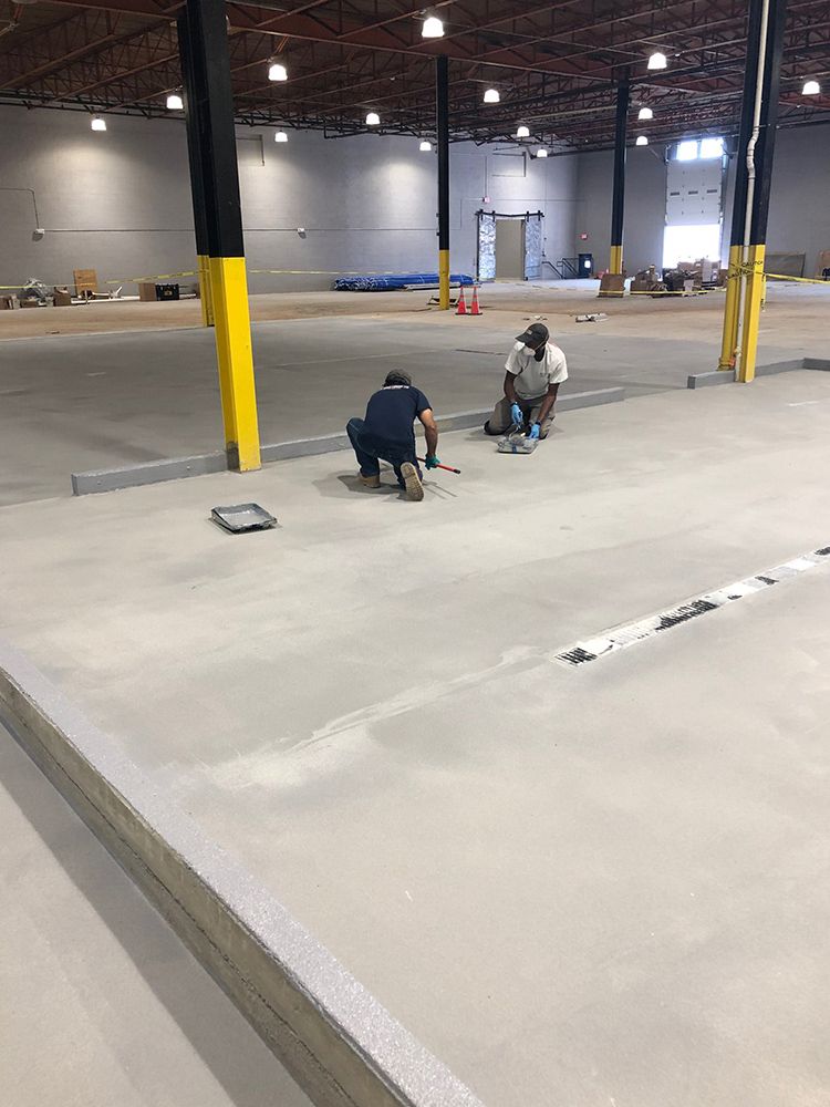 Two men are working on the floor of a large brewery.