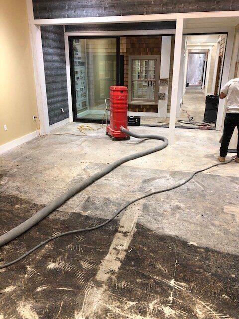 A man is cleaning the floor with a vacuum cleaner.