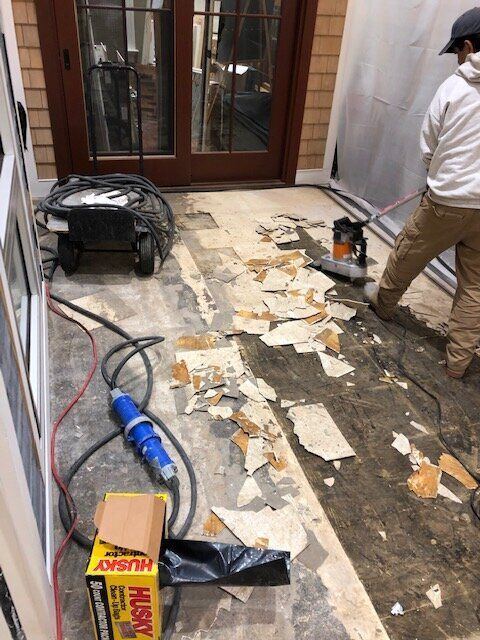 A man is cleaning the floor with a husky vacuum cleaner.