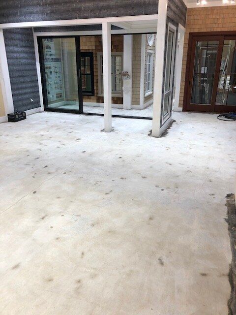 A room with a lot of windows and a concrete floor