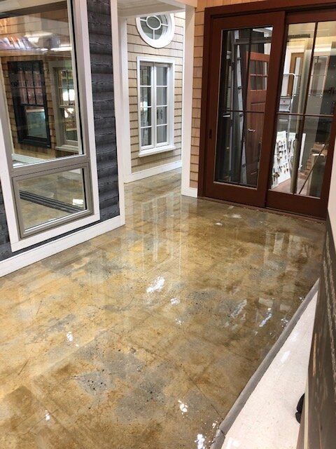 A room with a lot of windows and doors and a shiny floor.