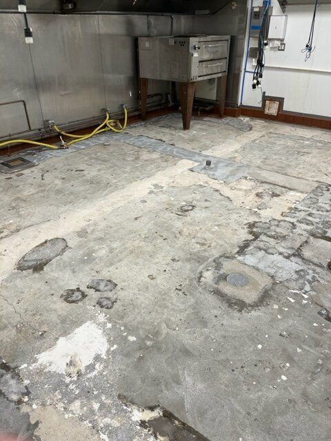 A kitchen with a sink and a dirty floor