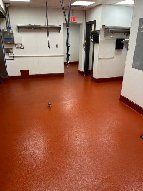A kitchen with a red floor and white walls