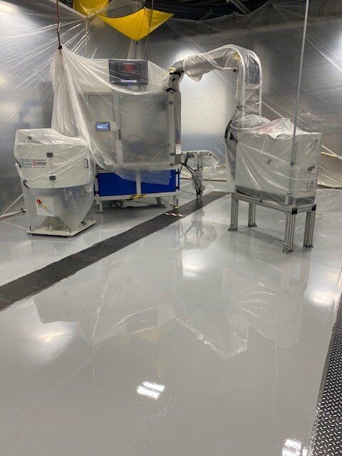 A machine is sitting in a room covered in plastic.