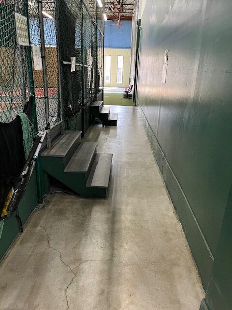 A long hallway with stairs leading up to a stadium.