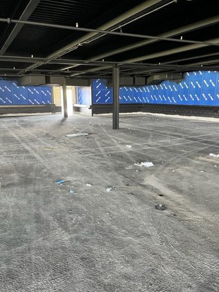An empty parking garage with a blue wall behind it