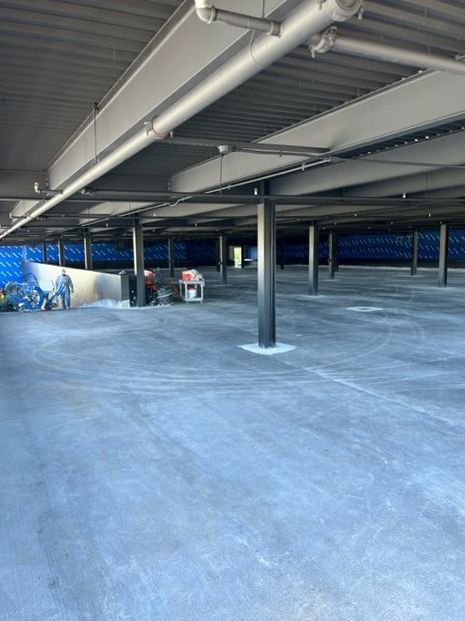 An empty parking garage with a blue tarp on the wall