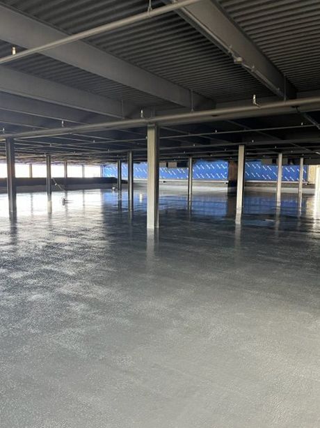 An empty parking garage with columns and a concrete floor