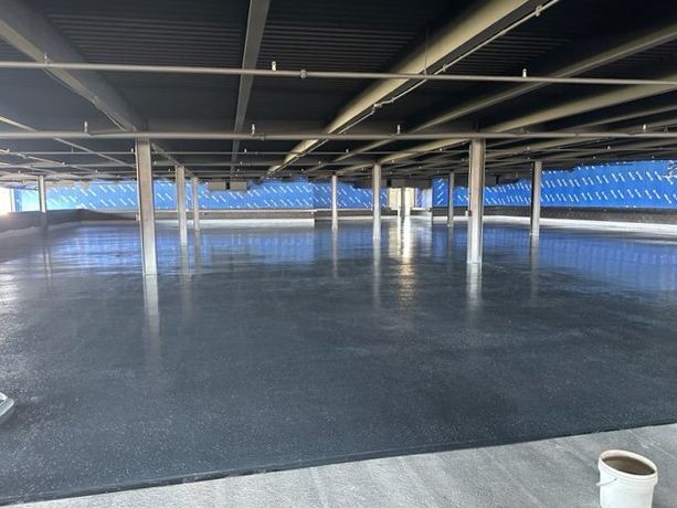 An empty parking garage with a bucket in the foreground