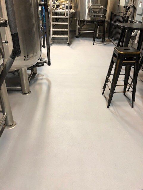 A room with a white floor and stools in it.