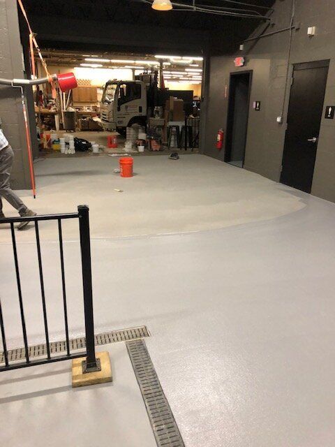 A truck is parked in a brewery next to a fence.