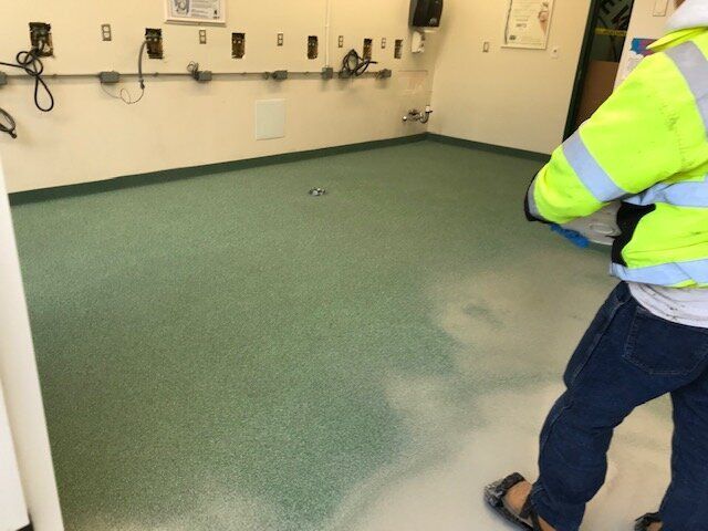 A person standing in a room with a green floor