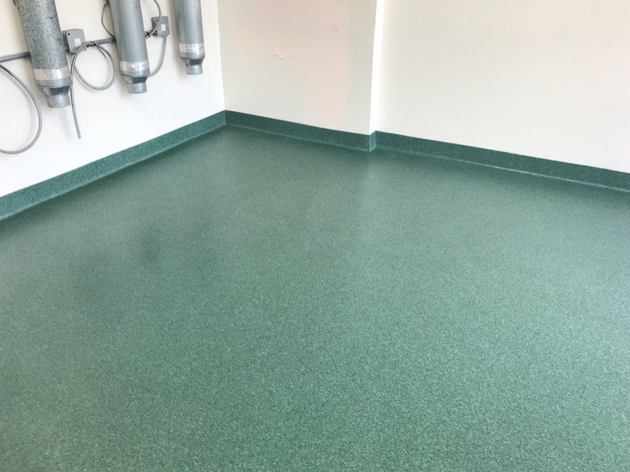 A room with a green floor and a white wall.