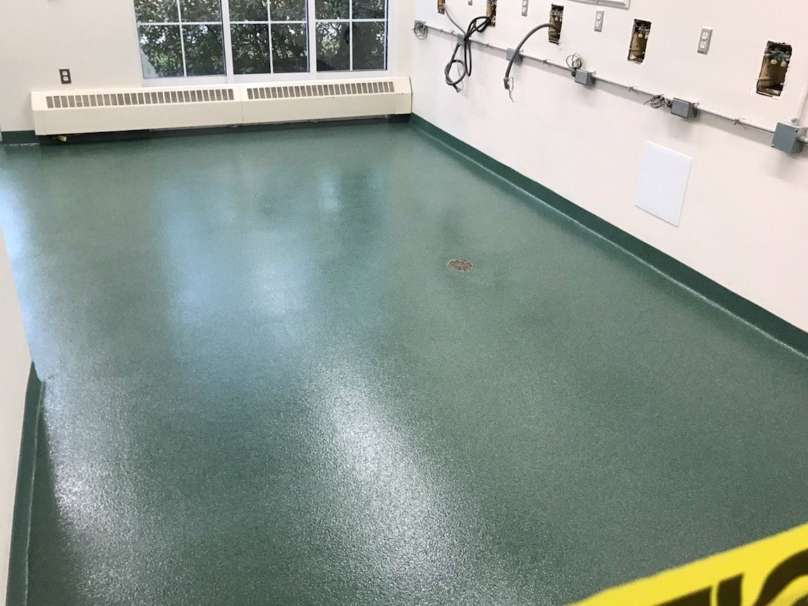 A room with a green floor and a yellow caution tape