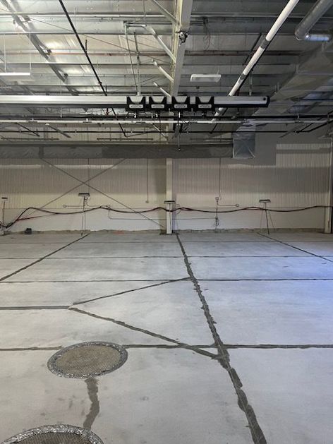 A large empty warehouse with a concrete floor and ceiling.