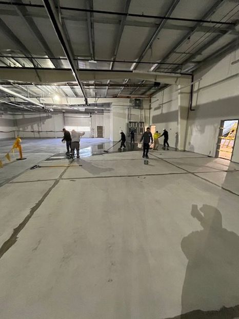 A group of people are working on the floor of a large building.