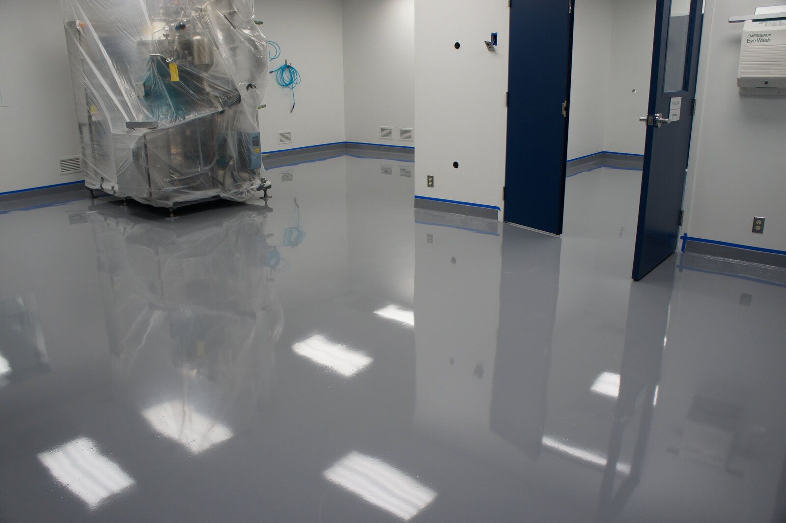 A room with a machine on the floor and a door.