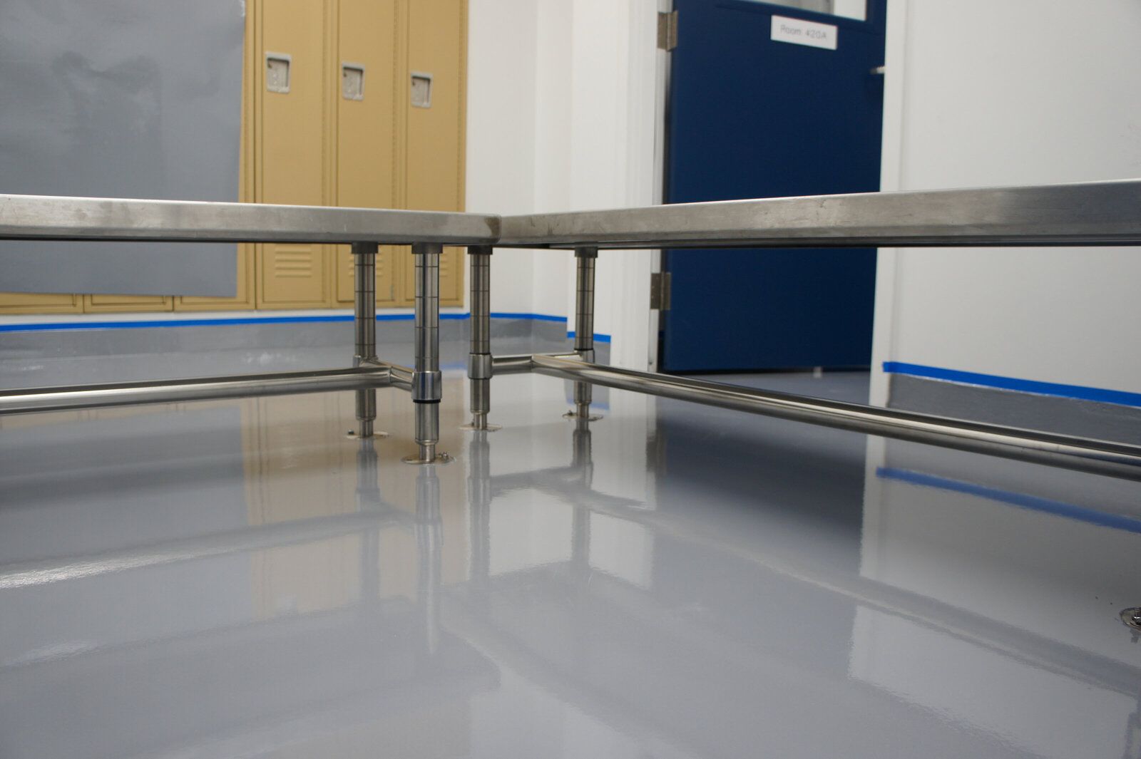 A stainless steel bench in a room with a blue door.