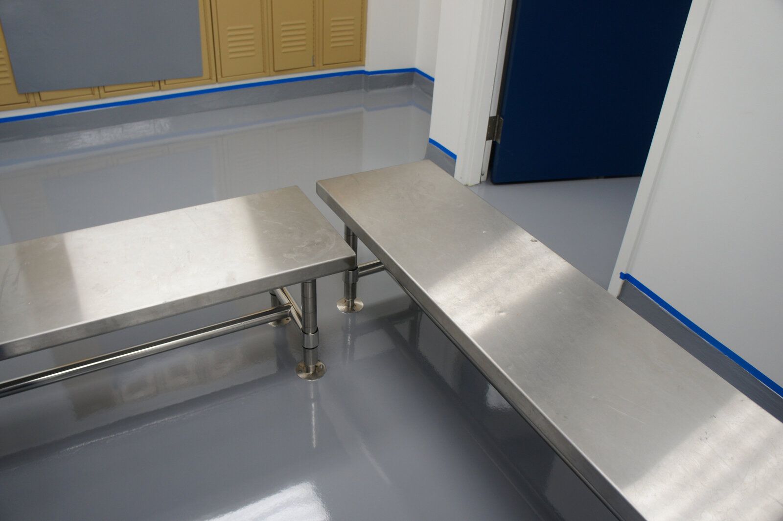 Two stainless steel benches are sitting next to each other in a room.