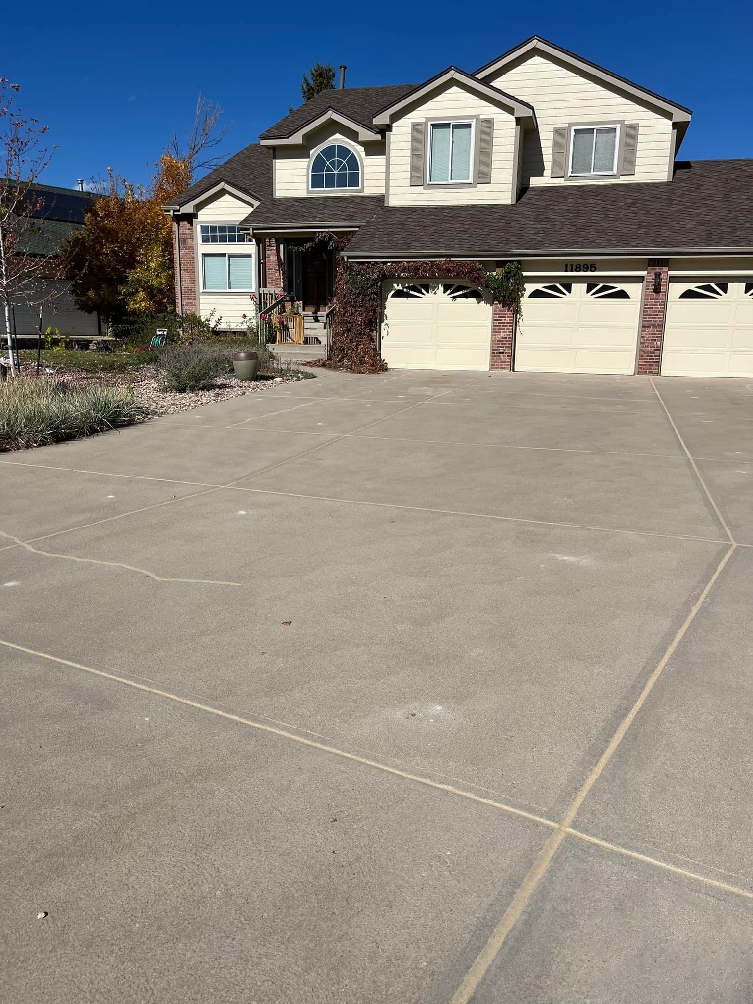 A large house with a concrete driveway in front of it.