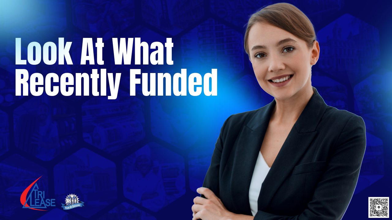 Businesswoman standing and smiling with look what we funded wording behind her.