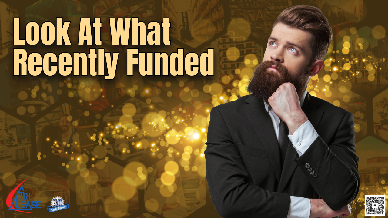 Businesswoman standing and smiling with look what we funded wording behind her.