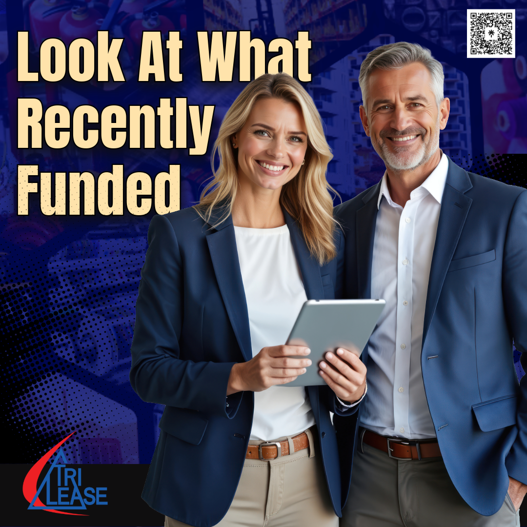 Two Business people reviewing recently financed equipment with various equipment in the background