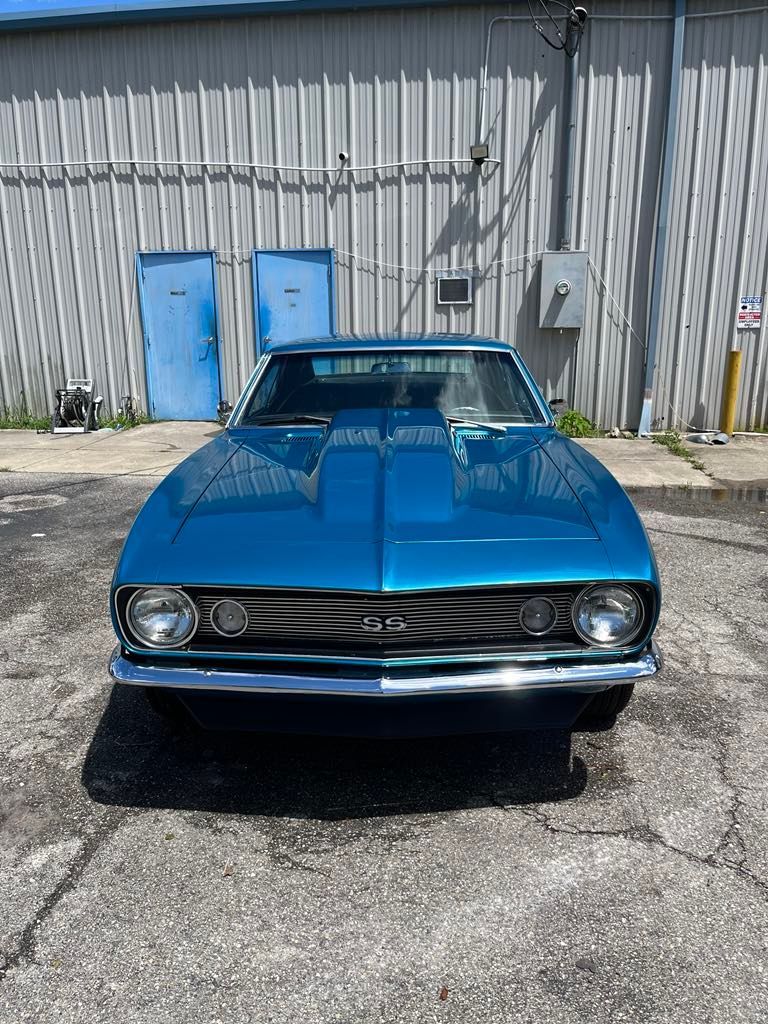 A blue car is parked in front of a building.