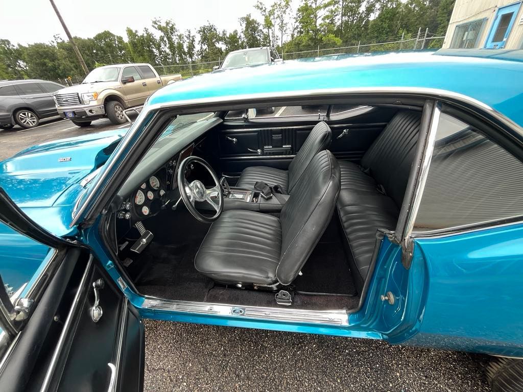 The inside of a blue car with the door open.