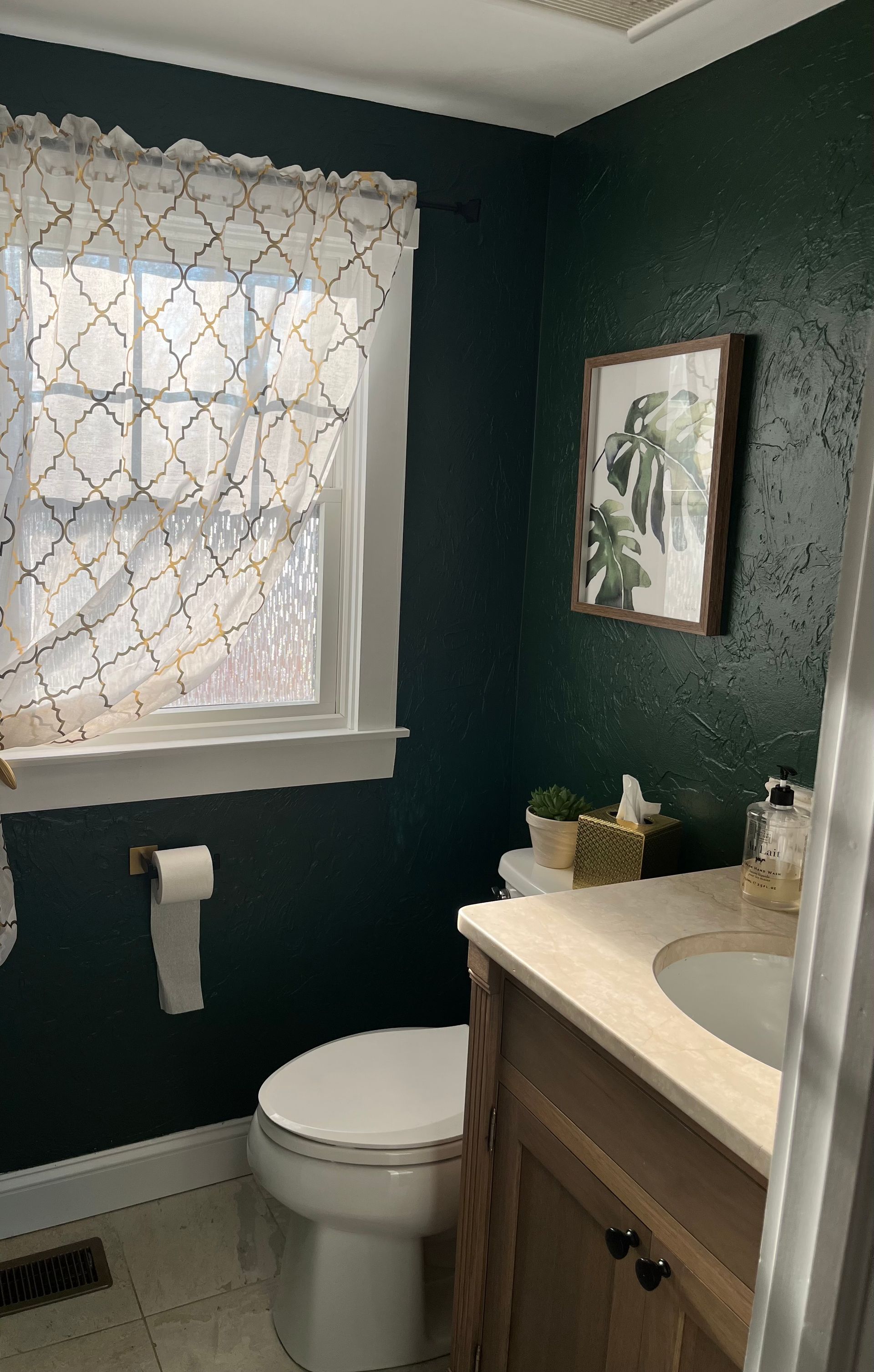 A bathroom with a toilet, sink, and window.