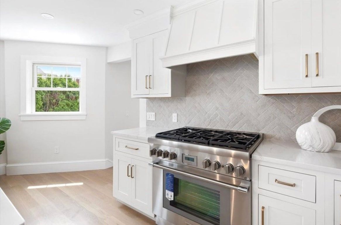 A kitchen with stainless steel appliances and white cabinets.