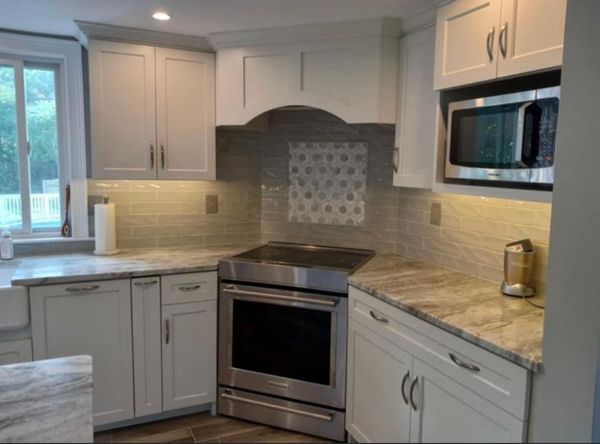 A kitchen with stainless steel appliances and white cabinets