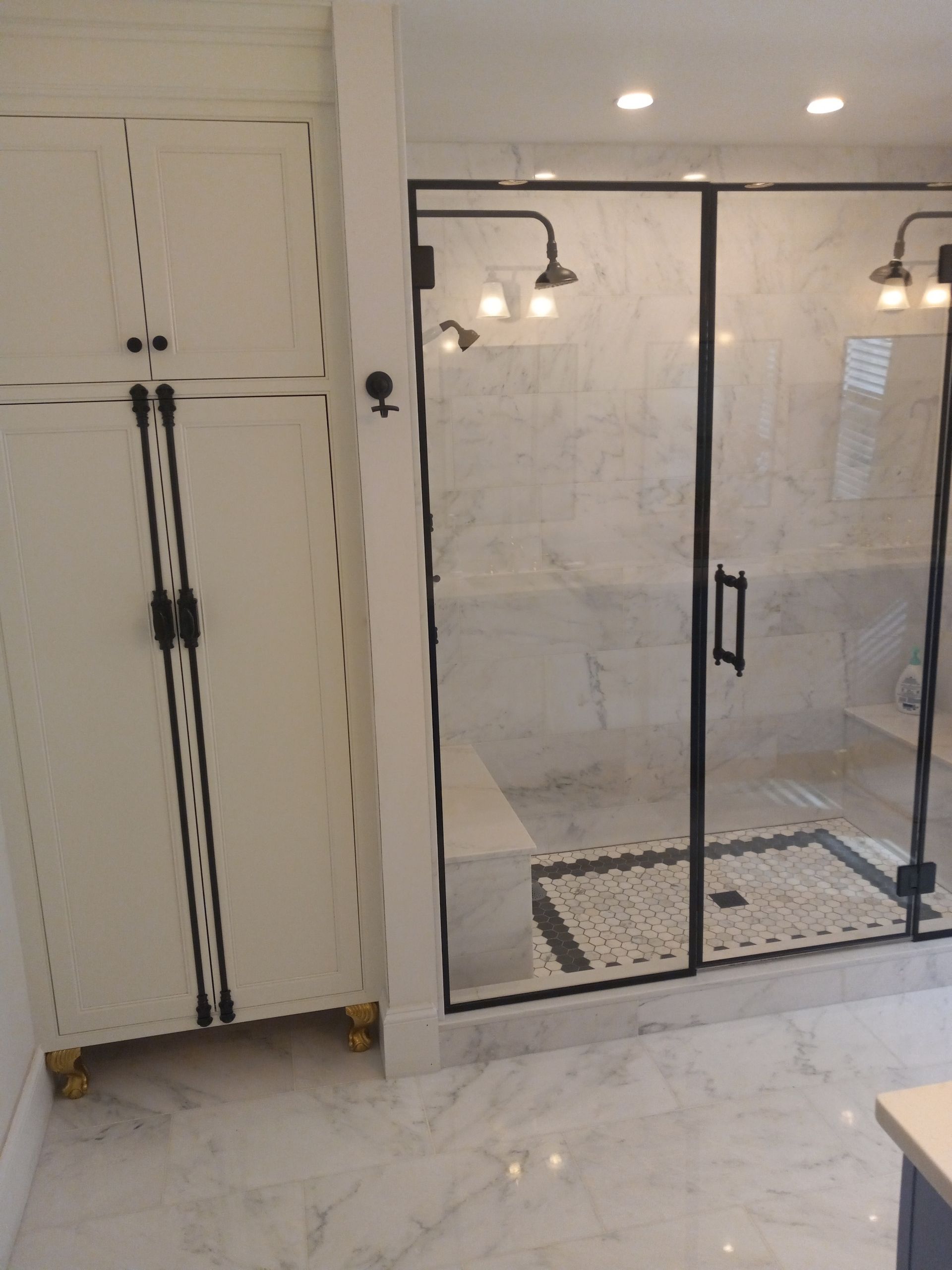 A bathroom with a walk in shower and a cabinet