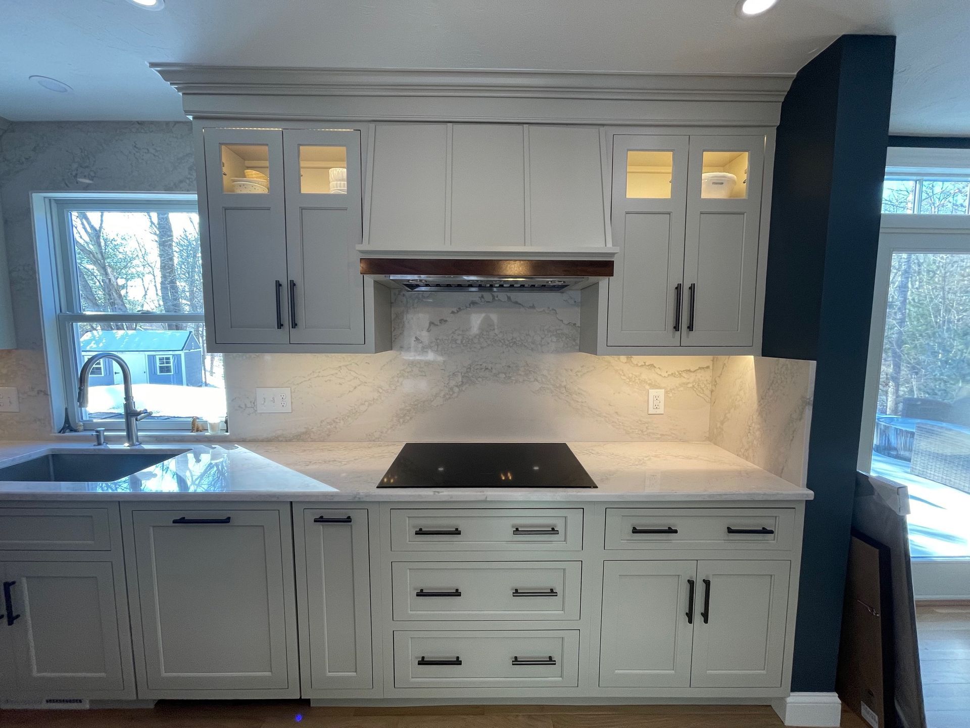 Kitchen with light gray cabinets, white countertops, and a black cooktop.