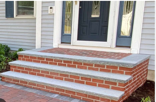 Brick front porch steps with white trim and dark blue front door