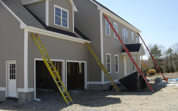 House under construction, supported by several ladders along the sides.