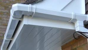 White rain gutter system installed on a building's roof with matching soffit.