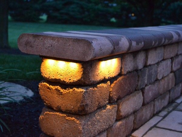 A brick wall with lights on it at night