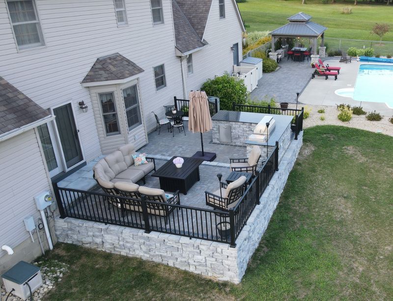 An aerial view of a backyard with a patio and a pool.