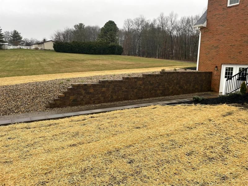 There is a brick wall in the backyard of a house.