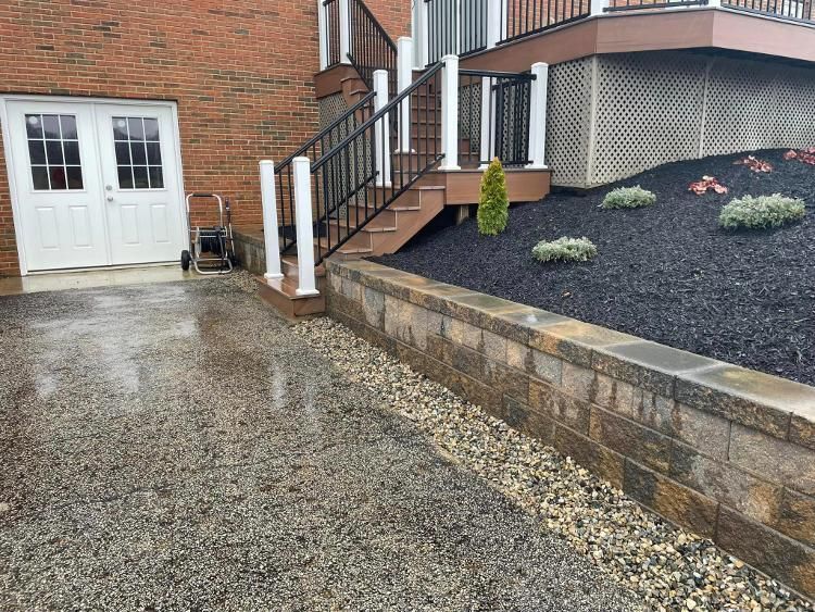 A brick building with stairs and a gravel driveway in front of it.