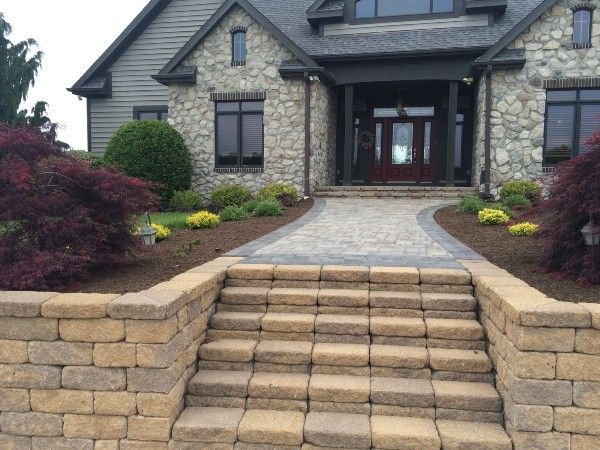 A stone house with stairs leading up to the front door