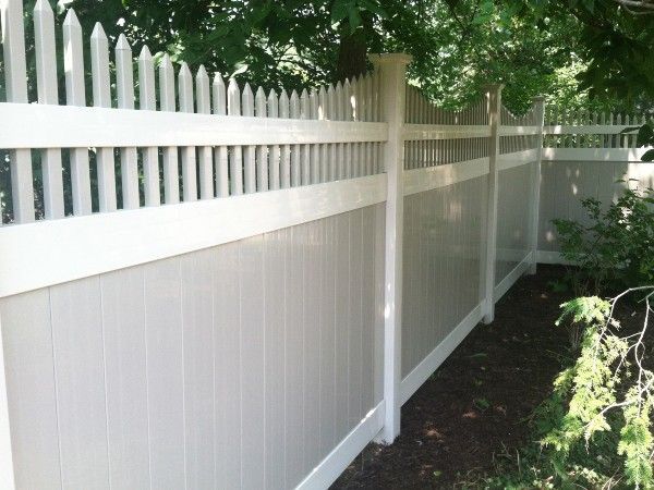 A white picket fence with a tree in the background